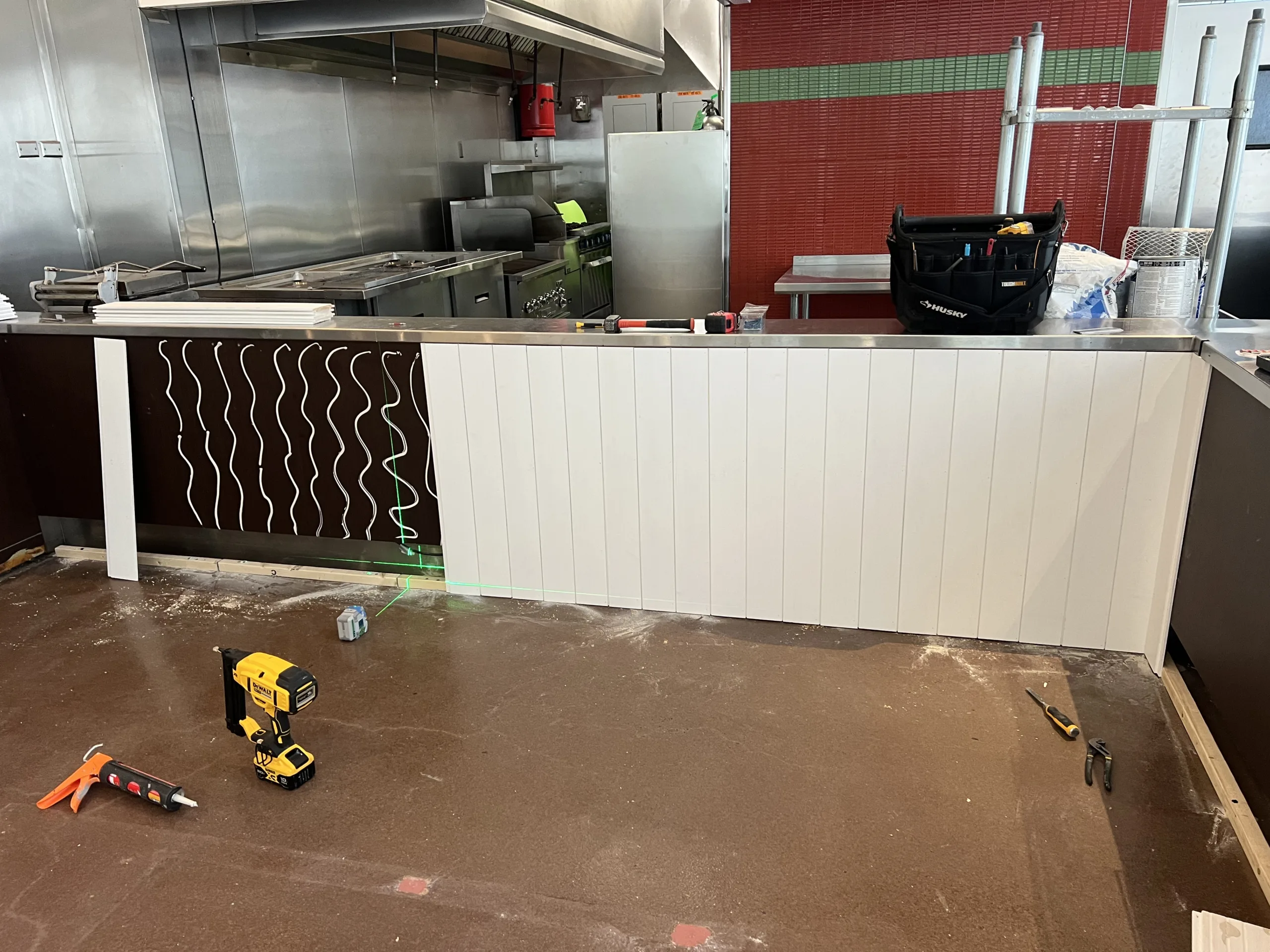 Bright white counter paneling and butcher block countertop during bakery remodel