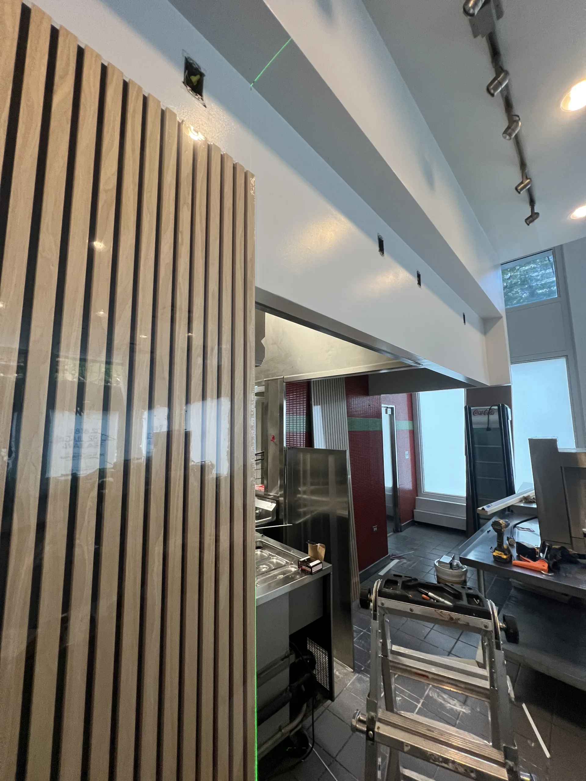 Vertical wood slat wall panels installed around bakery service opening