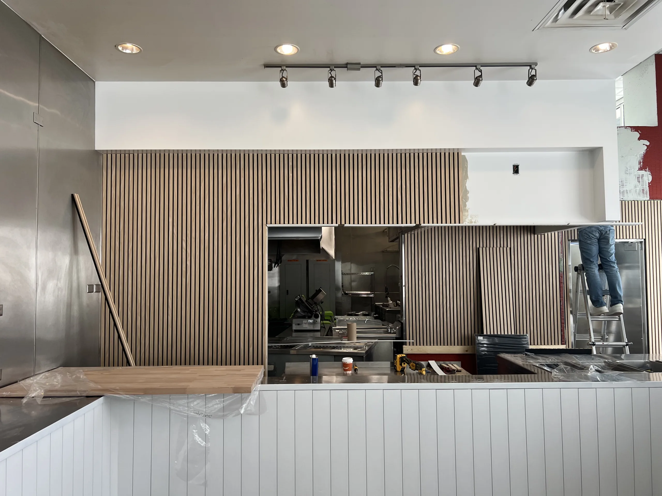 Finished white front counter panels with wood countertop in bakery interior