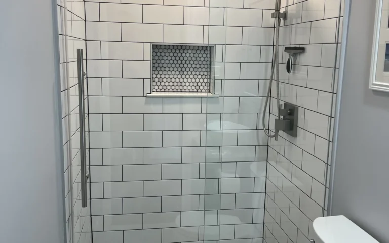 Modern walk in shower with white subway tiles and frameless glass door
