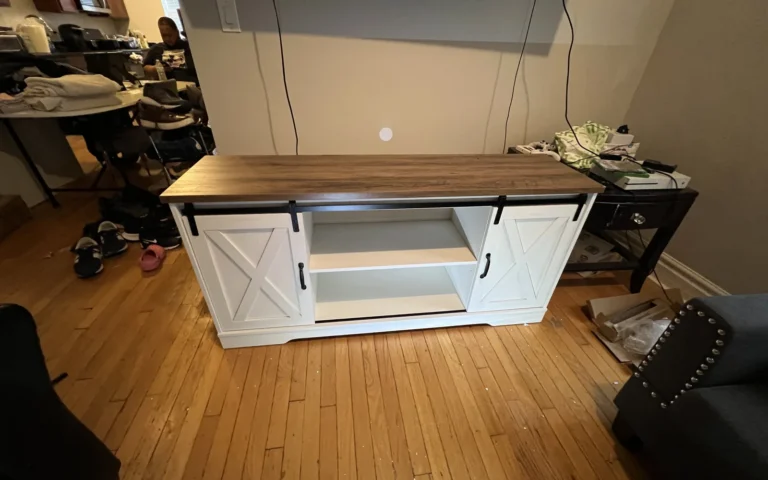 White TV stand with sliding barn doors and wood top assembled in living room