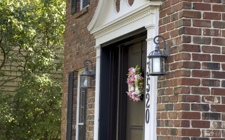 New black lantern light fixtures installed on brick wall beside front door