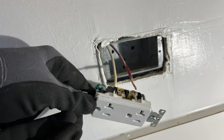 Handyman installing new electrical outlet replacing burned receptacle