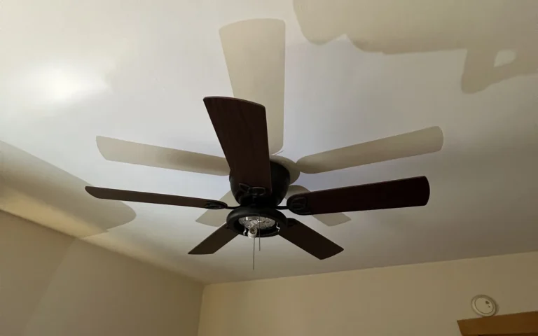 Installed dark wood ceiling fan with five blades and pull chain