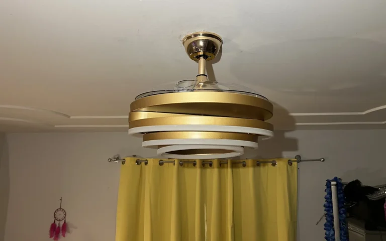 Modern gold and white ceiling fan light fixture installed on white ceiling