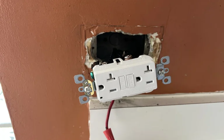 New GFCI electrical outlet installation in progress on brown wall with exposed wiring