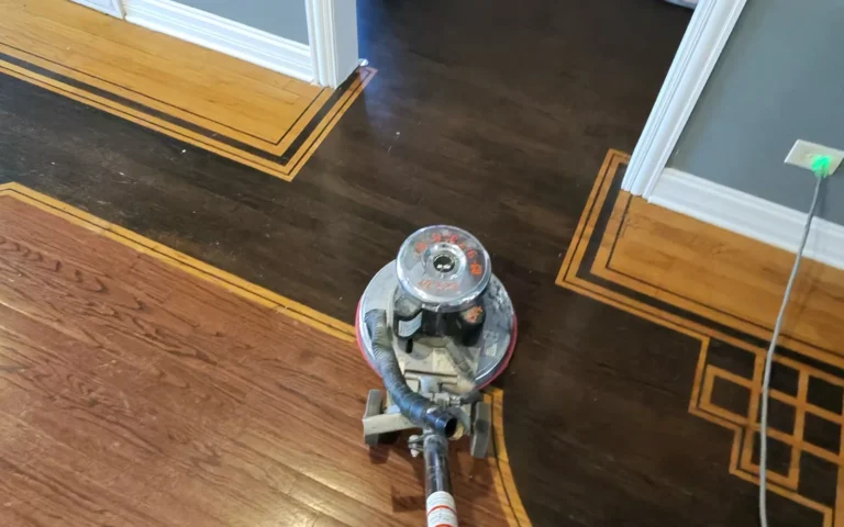 Handyman using floor buffer on hardwood floors with decorative inlay borders