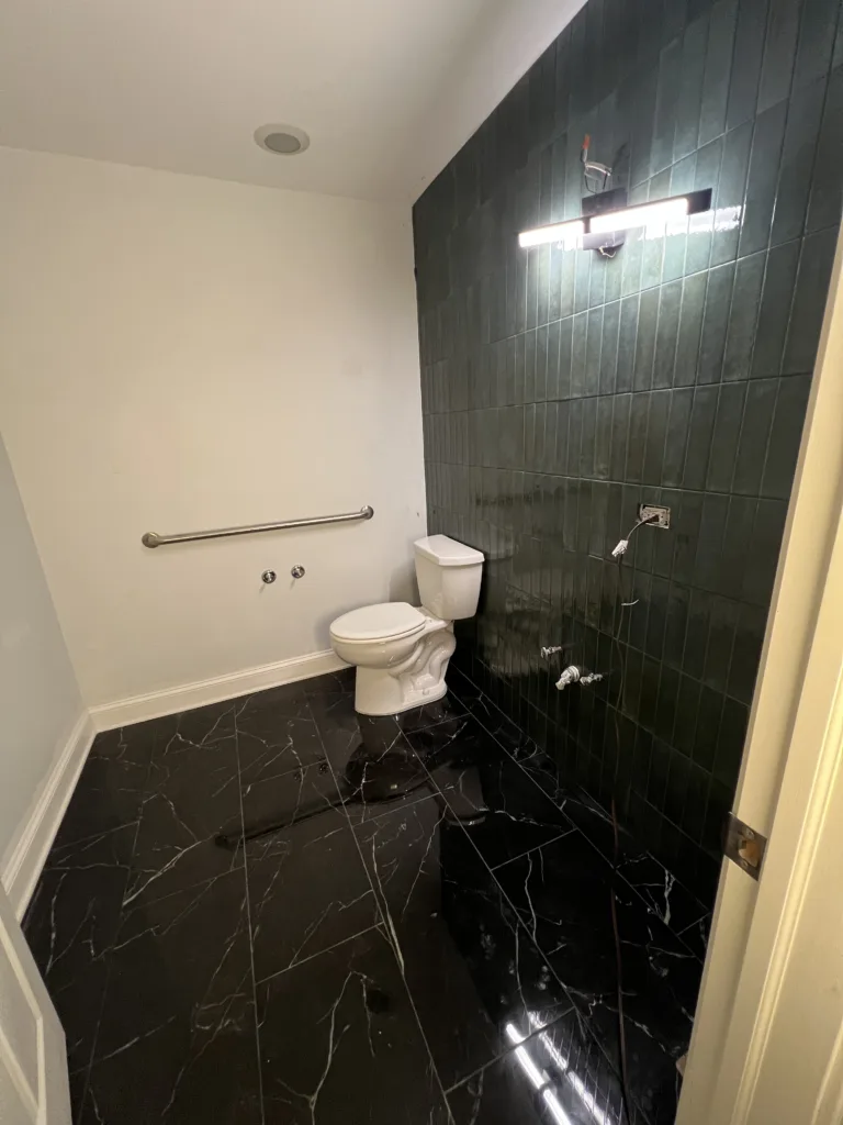 Office Restroom Remodel with Dark Green Wall Tile and Black Floor Tile in Chicago