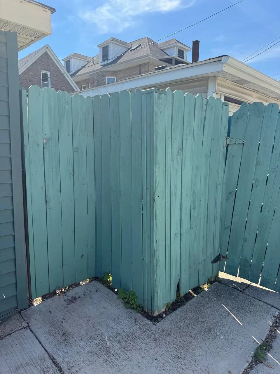 Damaged wood fence gate and panels before replacement in Chicago