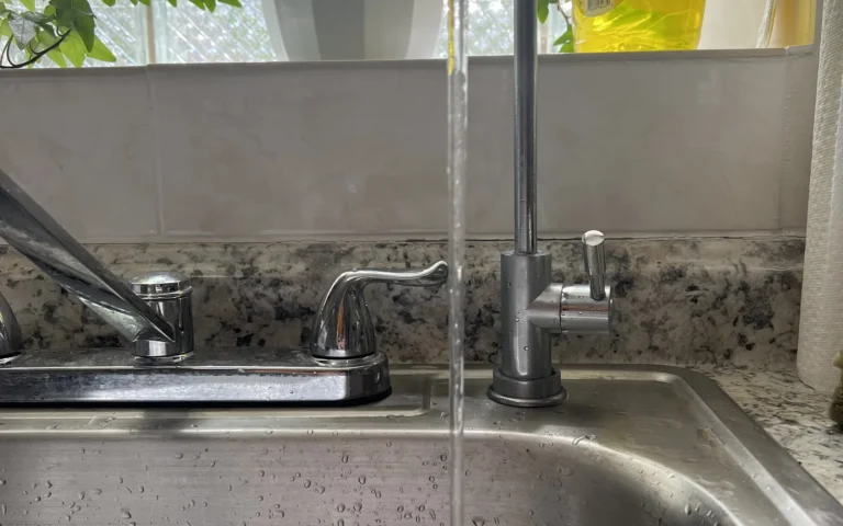 New water filter faucet installed in kitchen sink with water running