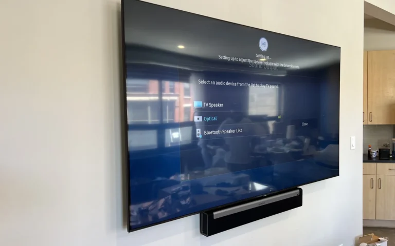 Wall mounted TV and soundbar displaying audio setup menu options