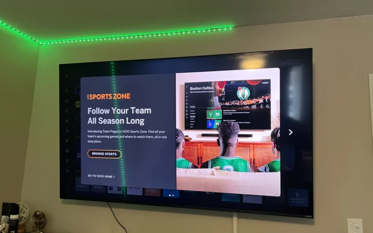 Wall mounted Vizio TV displaying sports interface with green LED accent lighting