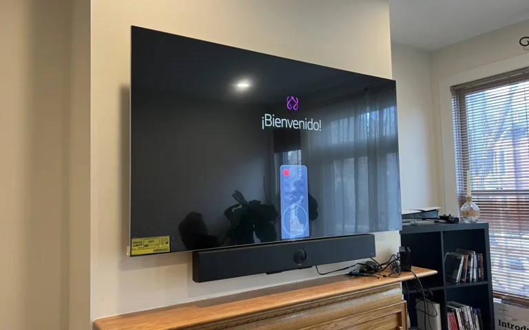 TV mounted on wall above fireplace with soundbar and cable management