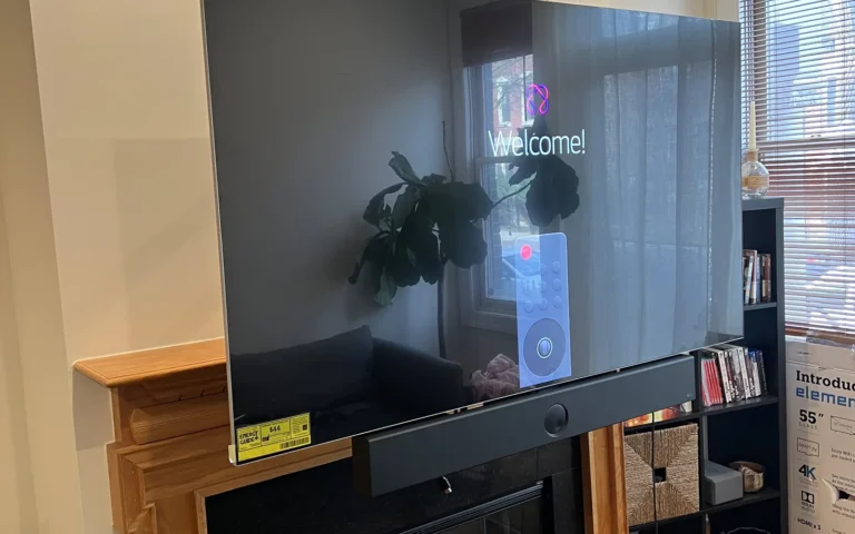 New TV mounted above fireplace with soundbar and welcome screen visible